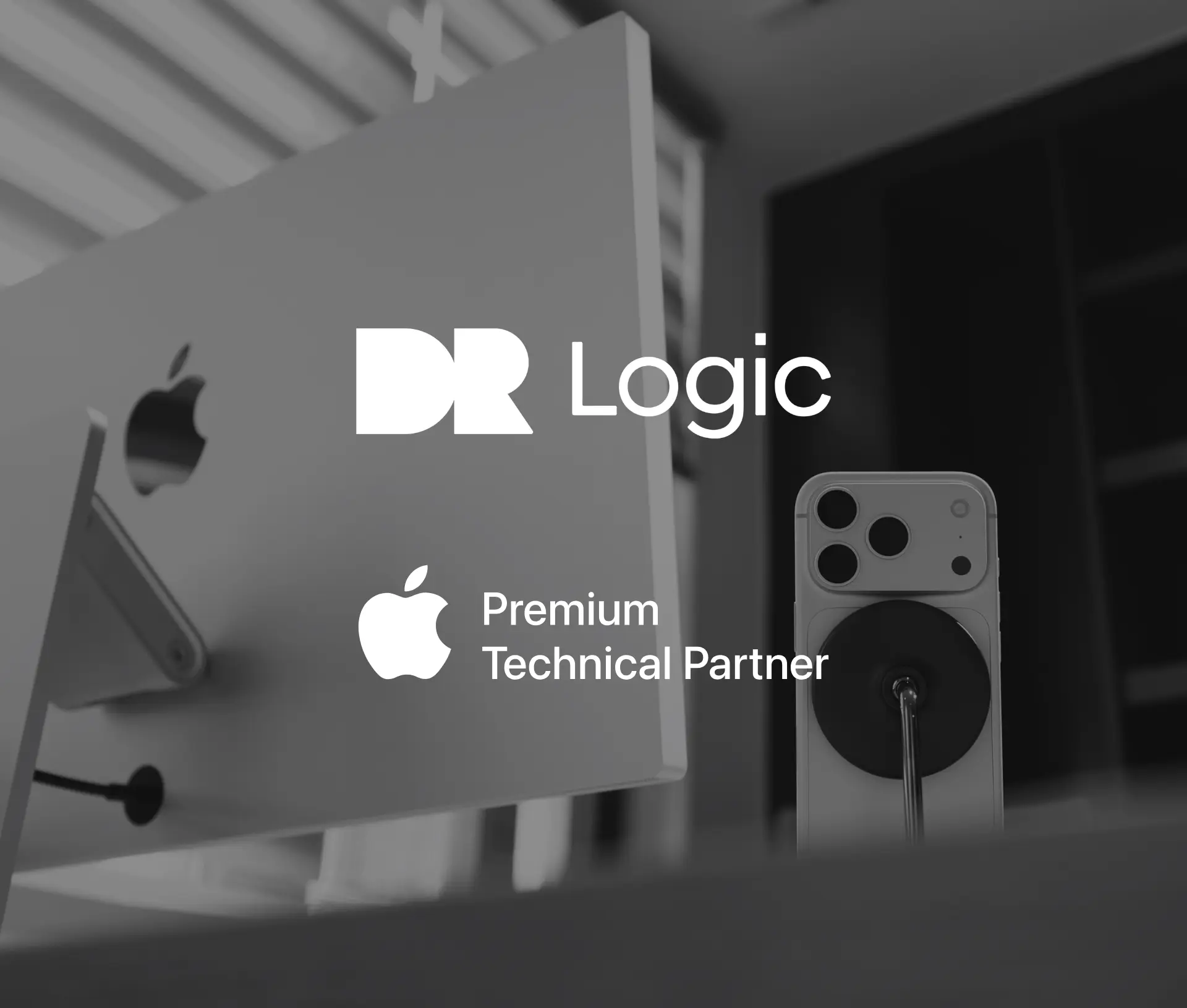 A greyscale image showing the back of an Apple iMac and an iPhone on a stand, with the Dr Logic logo and 