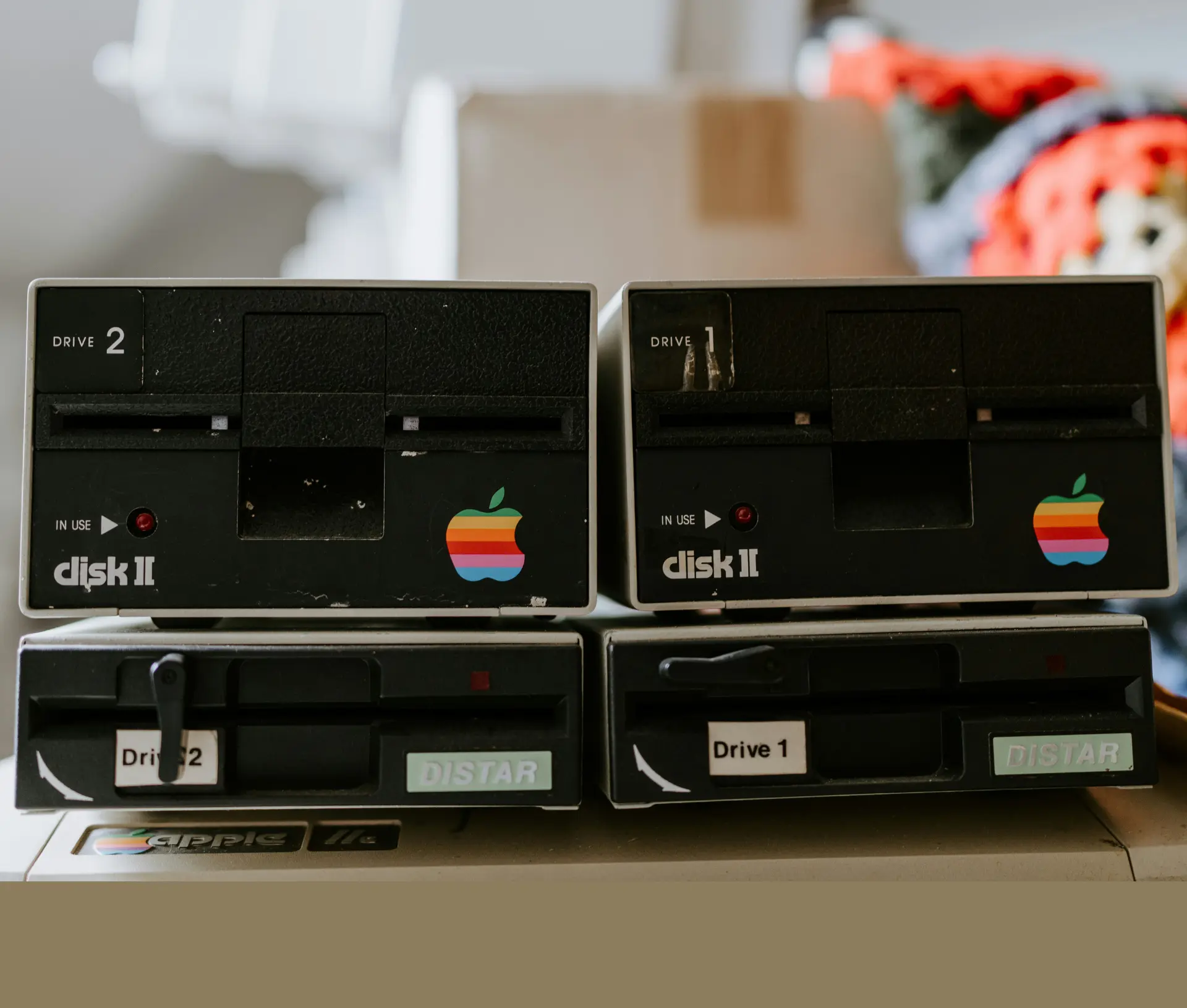 Two vintage Apple Disk II floppy drives with rainbow Apple logos labelled 