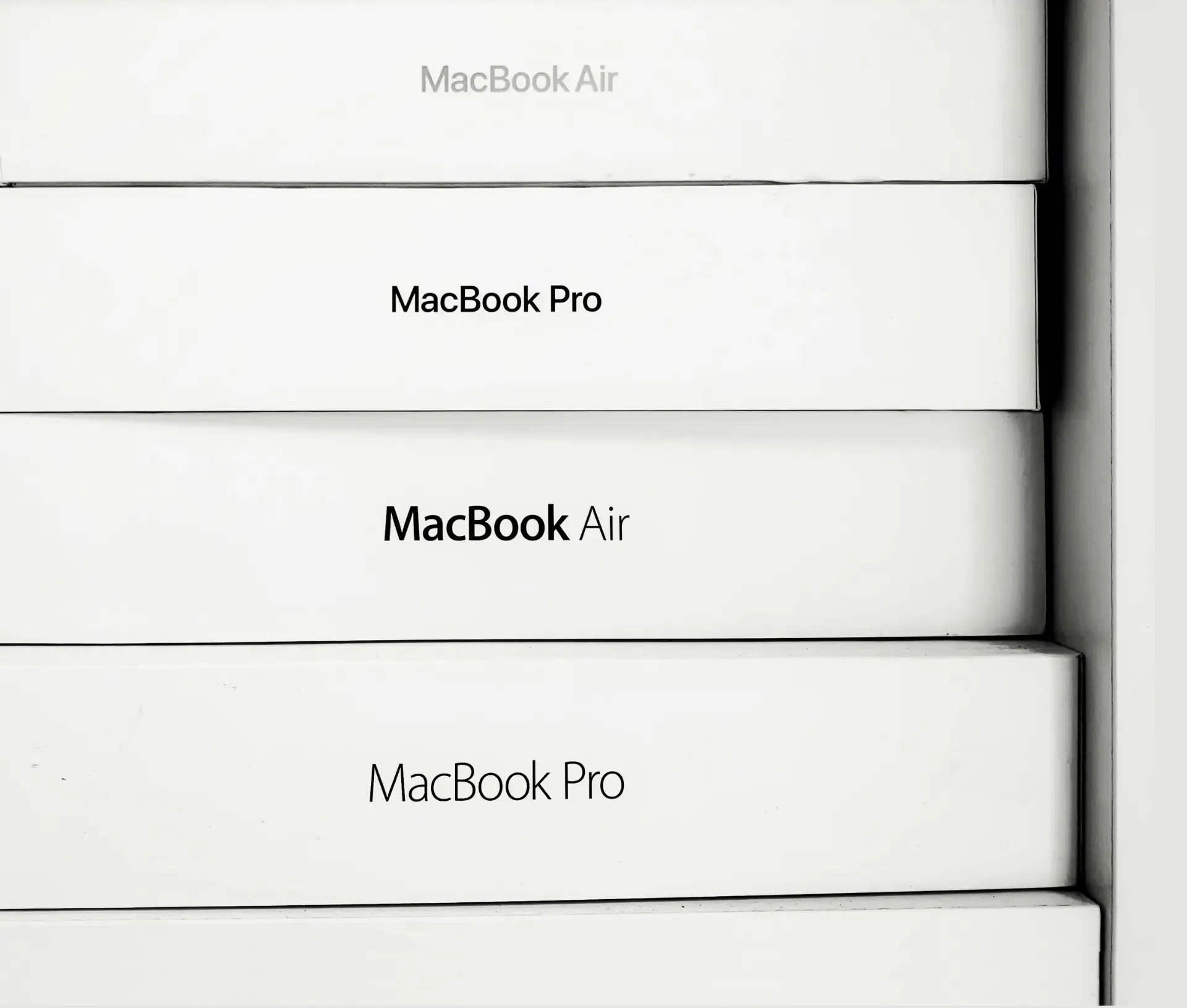 Stacked white Apple MacBook boxes labelled